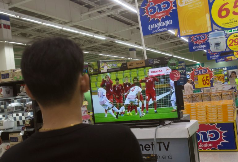 A Thai shopper watches a soccer match on a flat-panel television at s shopping mall in Bangkok, Thailand Wednesday, June 11, 2014. Thailandâs military junta, which promised to âreturn happiness to the peopleâ after last monthâs coup, has asked regulatory officials to find a way to allow the countryâs many soccer fans to watch all of the 2014 World Cup for free. (AP Photo/Sakchai Lalit)