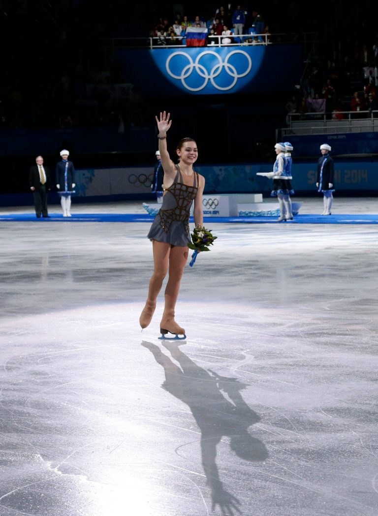 Adelina Sotnikova of Russia waves to spectators after placing first in the results area after completing her routine in the women's free skate figure skating finals at the Iceberg Skating Palace during the 2014 Winter Olympics, Thursday, Feb. 20, 2014, in Sochi, Russia. (AP Photo/Bernat Armangue)