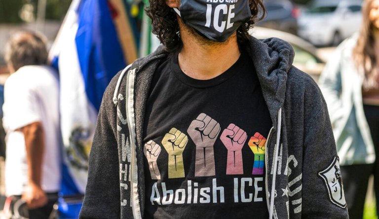 Protesters display a sign that reads "Abolish ICE" during a rally in front of the Immigration and Customs Enforcement facility in downtown Los Angeles on Monday, July 2, 2018. Protesters who were blocking the entrance to an Immigration and Customs Enforcement facility in downtown Los Angeles have been led away in handcuffs. A group of 17 protesters sat down in the street, blocking the entrance to the facility Monday morning. The protesters, including faith and community leaders, locked arms and chanted, "Shut down ICE!"
