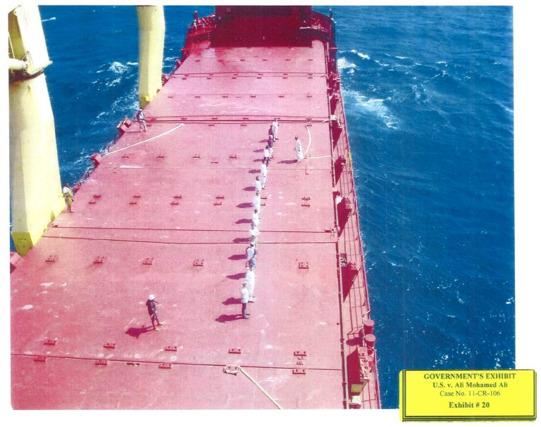 This image provided by the U.S. Attorney's Office shows government exhibit #20, a photo of the crew of the M/V CEC Future, which had been held by pirates for more than two months, standing in a line in January 2009, just before a $1.7 million ransom was paid. At right is Ali Mohamed Ali, who served as a translator and is being tried in Washington on piracy charges. The two men on the left and one man in the center are pirates. (AP Photo/U.S. Attorney's Office)