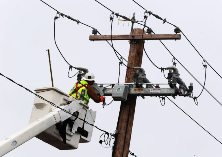 A worker examining a power line.