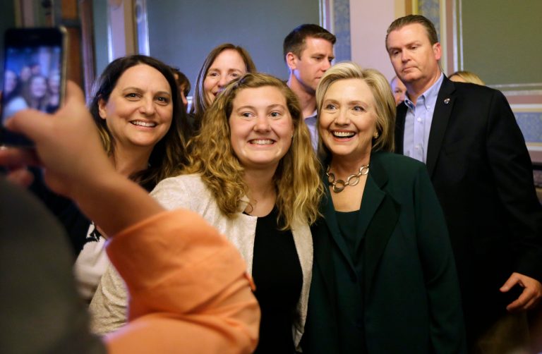 Democratic presidential candidate Hillary Clinton poses for a photo with Simpson College student MacKenzie Bills, center, after meeting with Iowa Democratic Party lawmakers at the Statehouse, Wednesday, April 15, 2015. (AP Photo/Charlie Neibergall)