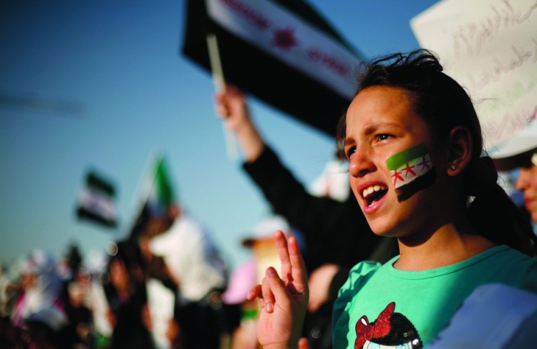 Syrian girl wears the colors of the revolutionary flag on her face and chants anti-Bashar Assad slogans during a protest in front the Syrian embassy in Amman, Jordan, Thursday, June 21, 2012. A Syrian fighter pilot on a training mission flew his MiG-21 warplane to Jordan on Thursday and asked for political asylum, the first defection of an air force pilot with his plane during the 15-month uprising against President Bashar Assad.(AP photo/Mohammad Hannon)