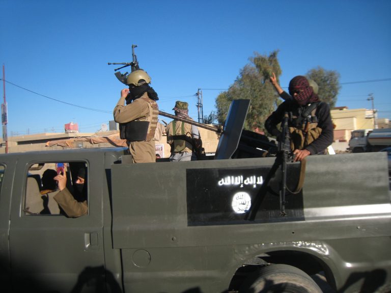 In this Thursday, March 20, 2014 file photo, Islamic State group militants patrol in a commandeered Iraqi security forces trucks sprayed with the representation of the al Qaeda flag and the Arabic that reads, 