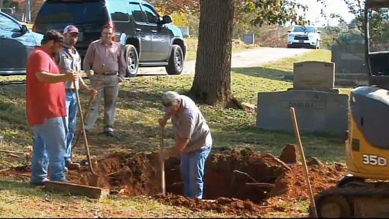 In this photo made from video and released by WSFA-TV, workers labor to exhume the body of a John Doe buried in Alabama in 1981, in Scottsboro, Ala. on Thursday, Oct. 9, 2014. The FBI is exhuming the body of a John Doe buried in Alabama in 1981 in its search for a 10 Most Wanted Fugitive accused of killing his family with a sledgehammer nearly 40 years ago. In court filings, the FBI said there is a strong resemblance between photos of the John Doe and former State Department diplomat William Bradford 