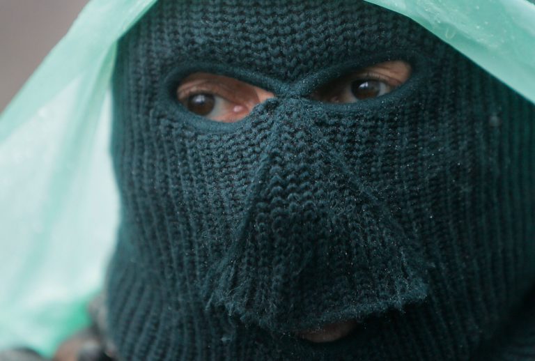 A pro-Russian gunman stands guard at a seized police station in the eastern Ukraine town of Slovyansk on Sunday, April 13, 2014.  Pro-Moscow protesters have seized a number of government buildings in the east over the past week, undermining the authority of the interim government in the capital, Kiev. (AP Photo/Efrem Lukatsky)