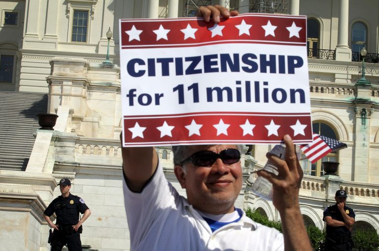 WASHINGTON, DC - APRIL 10:  An immigration activist holds up a sign on the West Lawn of the U.S. Capitol during an All In for Citizenship rally April 10, 2013 on Capitol Hill in Washington, DC. Tens of thousands of reform supporters gathered for the rally to call on Congress to act on proposals that would grant a path to citizenship for an estimated 11 million of the nation's illegal immigrants.  (Photo by Alex Wong/Getty Images)