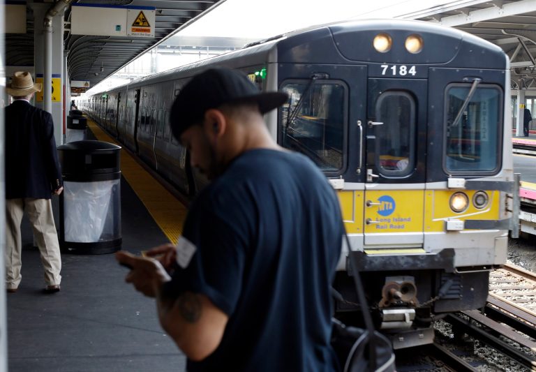 Pedestrians wait to ride a train at Jamaica station on the Long Island Rail Road Tuesday, July 15, 2014, in New York. Prospects of a strike which the unions said they were planning at 12:01 a.m. next Sunday, would affect 300,000 daily riders who travel in and out of New York City from Long Island. (AP Photo/Frank Franklin II)