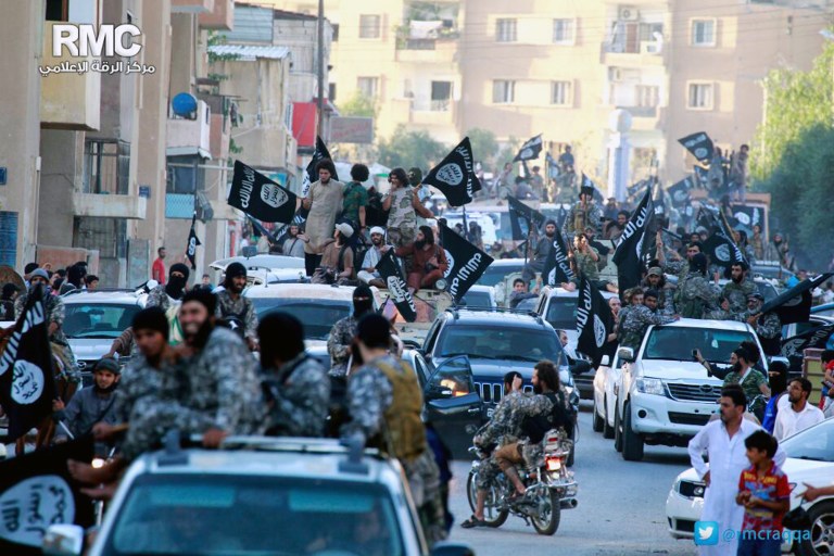 FILE - This undated file photo posted by the Raqqa Media Center, a Syrian opposition group, on Monday, June 30, 2014, which has been verified and is consistent with other AP reporting, shows fighters from extremist Islamic State group during a parade in Raqqa, Syria. Activists have reported two cases of stoning this month in the Syrian northern province of Raqqa. The first case of stoning occurred in the town of Tabqa. A day after the July 17, 2014, stoning of Shamseh Mohammed Abdullah, 26, Faddah al-Sayed Ahmad was stoned to death in the provincial capital of Raqqa. (AP Photo/Raqqa Media Center, File)