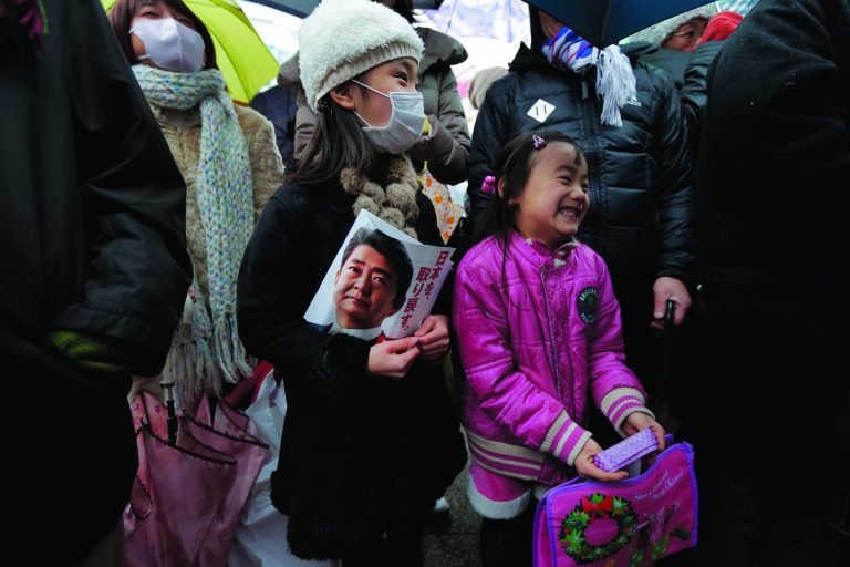 Children chuckle during a speech by Japan's main opposition Liberal Democratic Party (LDP) President Shinzo Abe during a campaign rally for the Dec. 16 parliamentary elections in Kawaguchi, near Tokyo, Saturday, Dec. 15, 2012. Candidates made final impassioned appeals Saturday to voters a day before Japanese parliamentary elections that are likely to hand power back to a conservative party that ruled the country for most of the post-war era. (AP Photo/Itsuo Inouye)