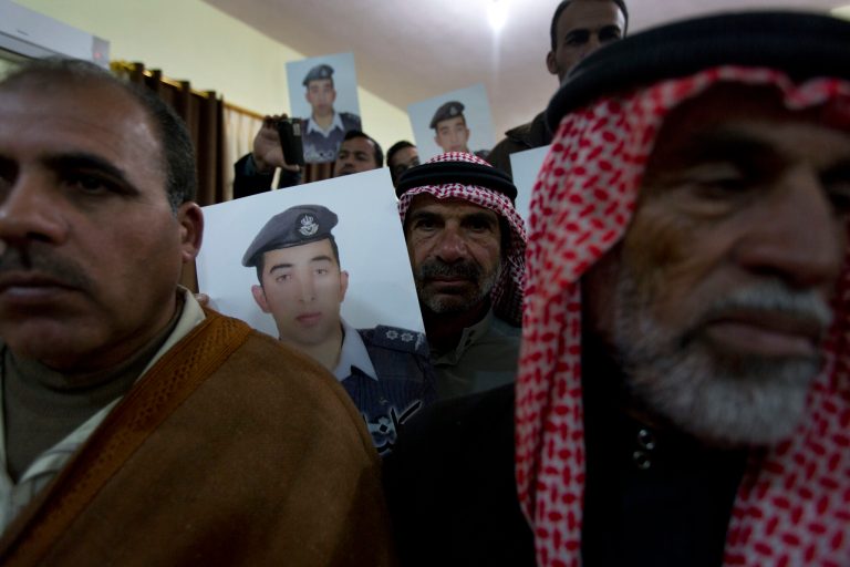 Members of Al-Kaseasbeh, the tribe of Jordanian pilot, Lt. Muath al-Kaseasbeh, who is held by the Islamic State group militants, carry posters with his picture and Arabic that reads 