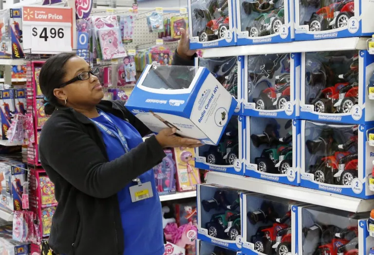 In this Nov. 26, 2013 file photo, toy department manager Gayla Harris stocks shelves for Black Friday sales at a Wal-Mart store in Oklahoma City.