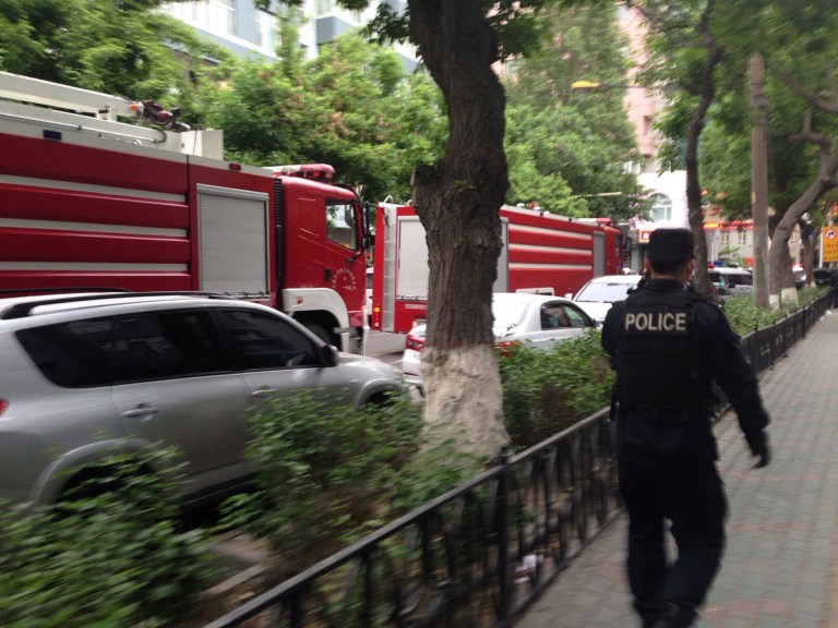 In this photo released by China's Xinhua News Agency, a police officer walks near a blast scene, which has been cordoned off, in downtown Urumqi, capital of northwest China's Xinjiang Uygur Autonomous Region, Thursday, May 22, 2014. Attackers crashed a pair of vehicles and tossed explosives in an attack Thursday near an open air market in the capital of China's volatile northwestern region of Xinjiang, leaving an unknown number of people dead and injured, state media reported. The official Xinhua News Agency said several people were rushed to hospital and flames and heavy smoke were seen at the scene, which was cordoned off. (AP Photo/Xinhua, Cao Zhiheng) NO SALES