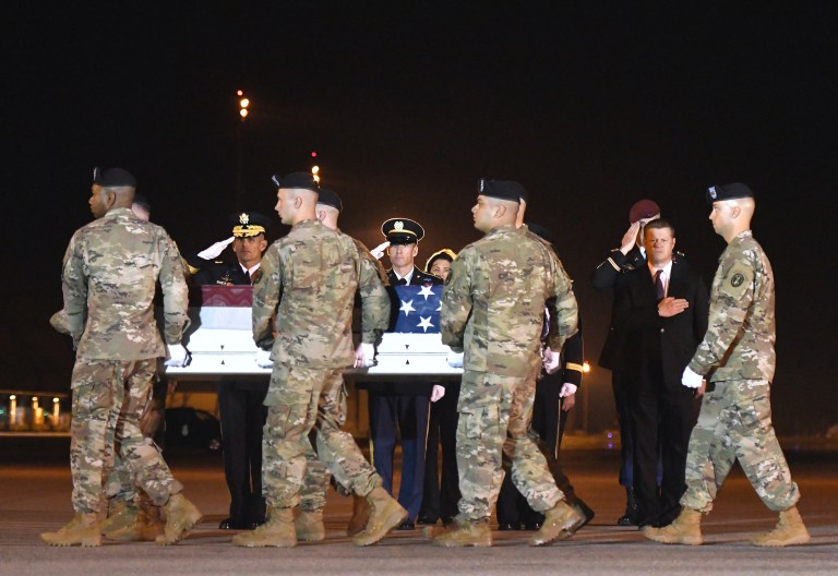 An Army carry team moves a transfer case containing the remains of Spc. Michael I. Nance past officials, including Secretary of the Army Ryan McCarthy, right, at Dover Air Force Base, Del., on Wednesday, July 31, 2019.