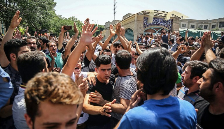 In this June 25, 2018 file photo, a group of protesters chant slogans at the main gate of the Old Grand Bazaar, in Tehran, Iran. On Saturday, Sept. 5, 2020, Iran broadcast the televised confession of a wrestler facing the death penalty after a tweet from President Donald Trump criticizing the case, a segment that resembled hundreds of other suspected coerced confessions aired over the last decade in the Islamic Republic. The case of 27-year-old Navid Afkari has drawn the attention of a social media campaign that portrays him and his brothers as victims targeted over participating in protests against Iran's Shiite theocracy in 2018.