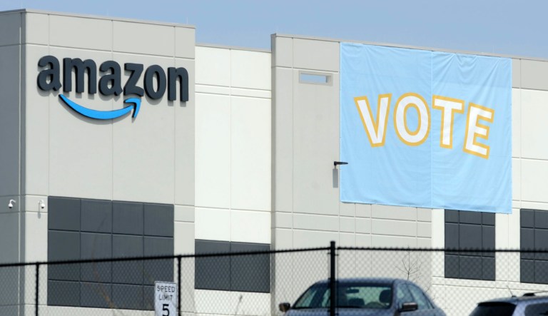 A banner encouraging workers to vote in labor balloting is shown at an Amazon warehouse in Bessemer, Ala., on Tuesday, March 30, 2021. Organizers are pushing for some 6,000 Amazon workers to join the Retail, Wholesale and Department Store Union on the promise it will lead to better working conditions, better pay and more respect. Amazon is pushing back, arguing that it already offers more than twice the minimum wage in Alabama and workers get such benefits as health care, vision and dental insurance without paying union dues.