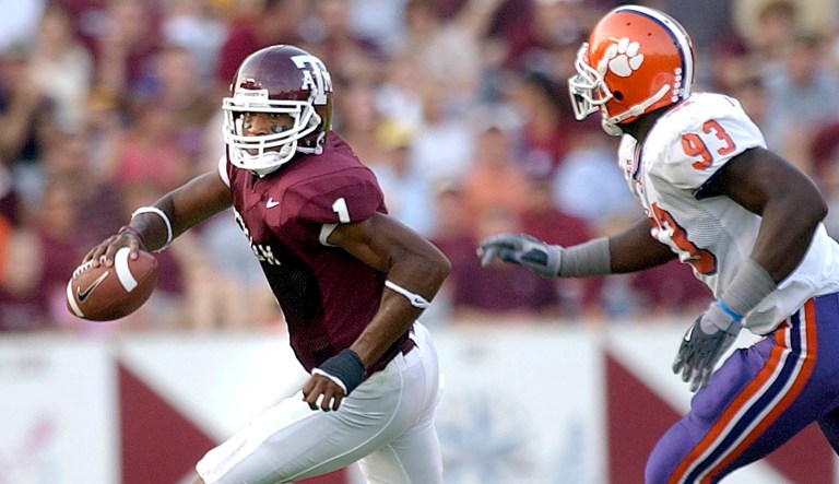 Texas A&M quarterback Regie McNeal looks to pass while under pressure from Clemson defender Gaines Adams in the first quarter in College Station, Texas, Sept. 18, 2004.