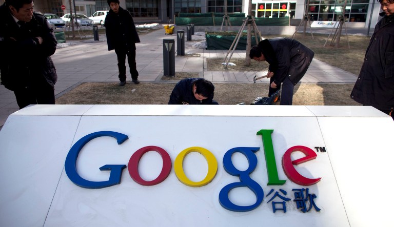 Workers repair a partially broken marble tablet which bears Google's logo in front of Google China's headquarters building in Beijing.
