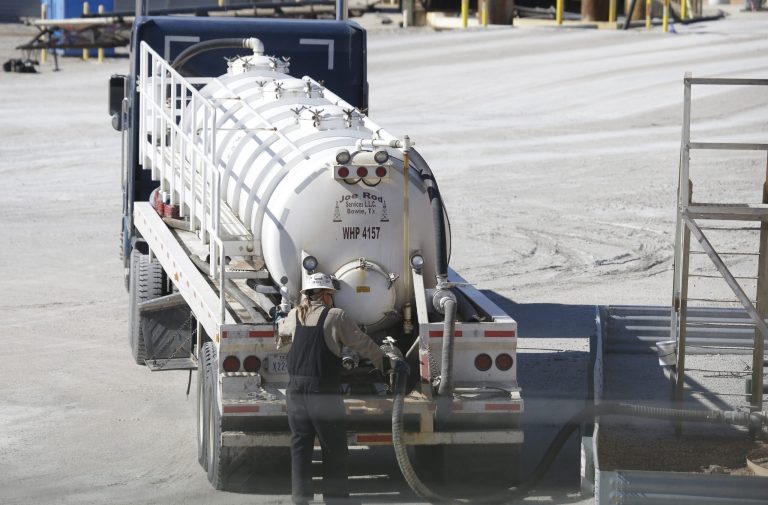 In this Wednesday, Nov. 19, 2014 photo, truck driver works a taker truck at a fracking wast water storage facility siting just outside the city limits of Reno, Texas. New technology has opened the door to tapping a huge new site in Texas and New Mexico.