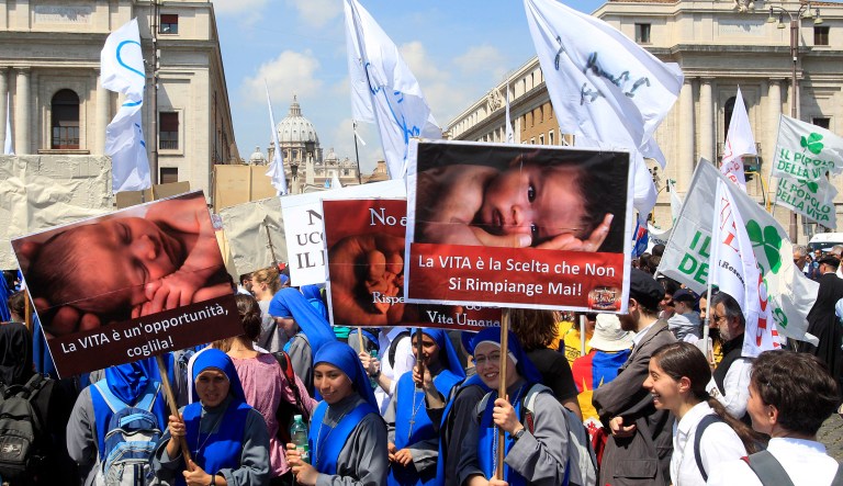 Nuns hold signs during an anti-abortion march as the dome of St. Peter's Basilica is seen in background, in Rome, Sunday, May 13, 2012. A few thousand people opposed to Italy's 1978 law allowing abortion have marched from the Colosseum to Castel Sant'Angelo, a landmark near the Vatican, in a protest drawing people from around the world, including Americans and Poles. 