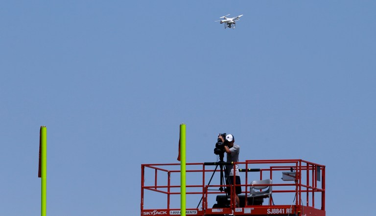 A drone hovers over the practice field during a Dallas Cowboys organized team activity at the NFL football team's headquarters, Wednesday, June 10, 2015, in Irving, Texas. The FAA is investigating the use of the drones by the Cowboys and two other NFL teams.