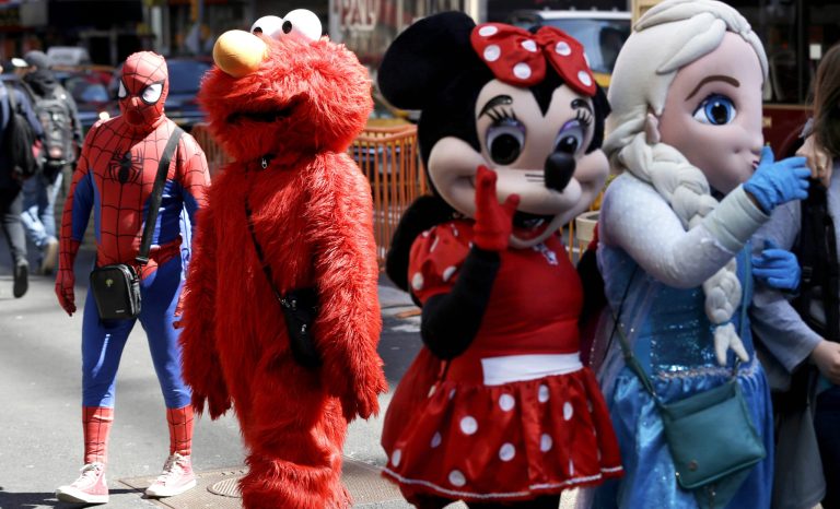 In this March 29, 2016 photo, costumed characters work for tips in New York's Times Square. 