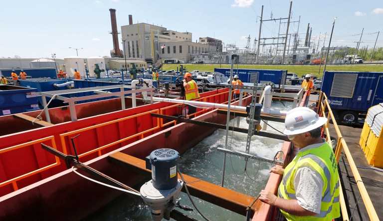 Workers look over wastewater from coal ash as it is aerated in a treatment facility outside Dominion Powers Bremo Bluff power plant in Bremo Bluff, Va.