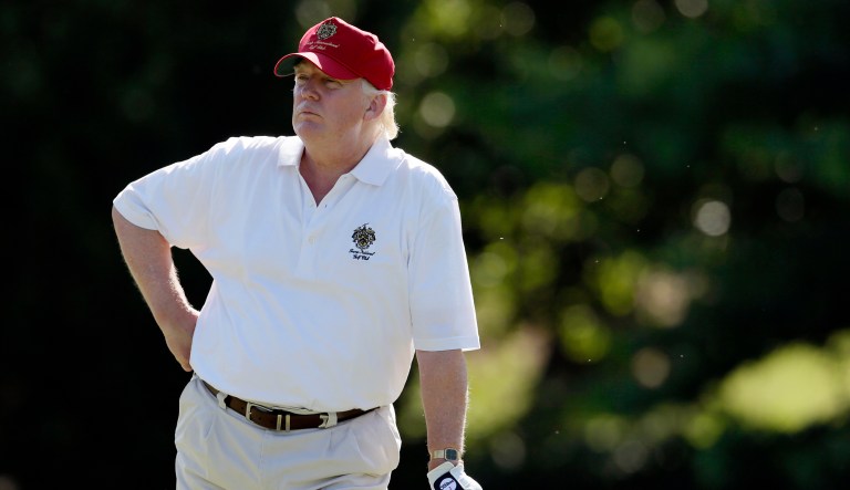 In this photo, President Trump stands during a game of golf at a country club.