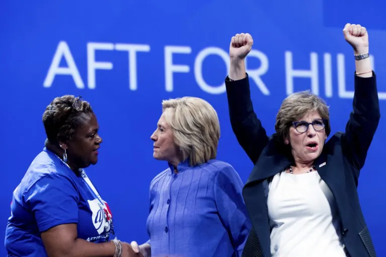 Democratic presidential candidate Hillary Clinton, center, greets a supporter on stage with AFT President Randi Weingarten.