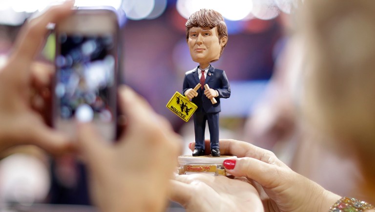 Delegates take pictures of a Donald Trump bobble-head doll before the start of final day of the Republican National Convention.