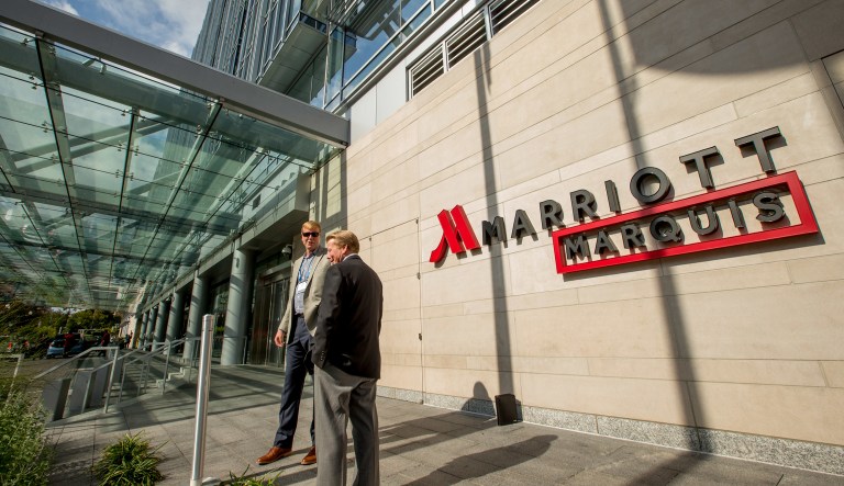 In this Wednesday, Oct. 14, 2015, file photo, two men stand outside the newly-built Marriott Marquis hotel in Washington. Marriott International closed early Friday, Sept. 23, 2016, on its acquisition of Starwood Hotels & Resorts Worldwide, bringing together its Marriott, Courtyard and Ritz-Carlton brands with Starwoodâs Sheraton, Westin, W and St. Regis properties.