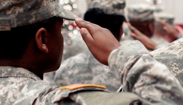 FILE - In this Wednesday Dec. 5, 2012, file photo, soldiers salute the U.S. flag during the Pledge of Allegiance at a welcome home ceremony for soldiers returning from a deployment in Afghanistan, at Fort. Carson, Colo. For veterans, the GI Bill can be the ticket to a debt-free college education.