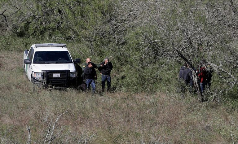 In this Tuesday, Nov. 15, 2016, photo, a U.S. Customs and Border Patrol agents stop a group of suspected illegal immigrants passing through a ranch near Edinburg, Texas.