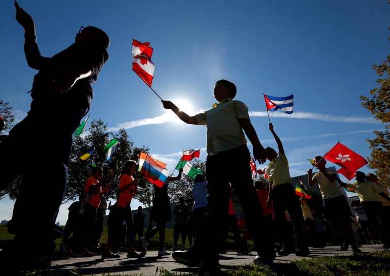 In this Thursday, Sept. 17, 2015 file photo, students from Public School 3 in Jersey City, N.J., wave flags representing the nations of origin of immigrants who became U.S. citizens during a ceremony at Liberty State Park in Jersey City, N.J.