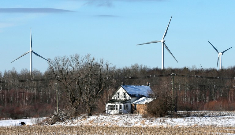 In this Jan. 15, 2017 photo, large energy producing wind turbines in the Noble Ellenburg Windpark tower above a farmhouse in Ellenburg, N.Y.