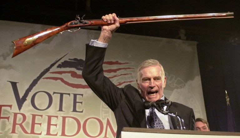 In this Oct. 21, 2002 photo, National Rifle Association President Charlton Heston holds up a rifle as he addresses gun owners during a "get-out-the-vote" rally in Manchester, N.H. 