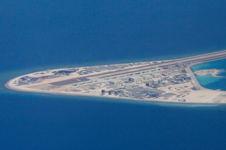 In this 2017 file photo, an airstrip, structures and buildings on China's man-made Subi Reef in the Spratly chain of islands in the South China Sea are seen from a Philippine Air Force C-130 transport plane of the Philippine Air Force.