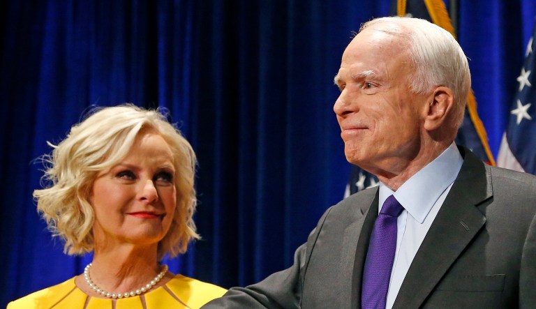 Sen. John McCain, R-Ariz., accompanied by his wife Cindy McCain, pauses after speaking in Phoenix.