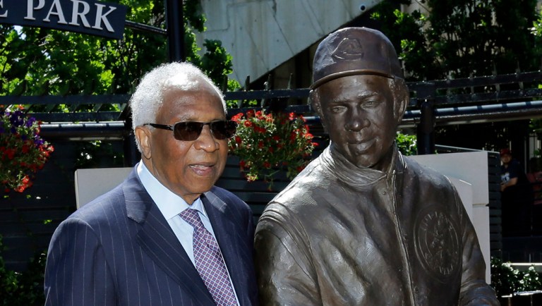Frank Robinson poses with his statue.