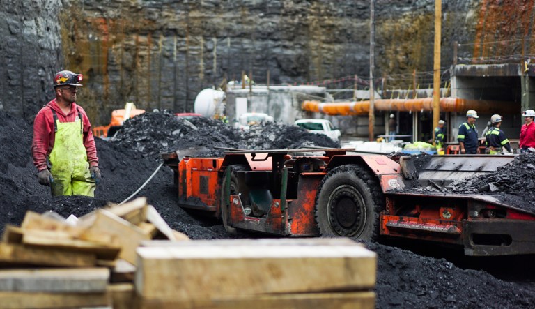 A worker waits for a piece of heavy machinery to pass by at a new coal mine in Friedens, Pa.