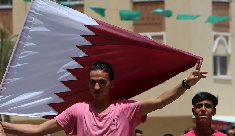 A youth holds a Qatari flag during demonstration in solidarity with Qatar in front of Sheikh Hamad bin Khalifa al-Thani's mosque in the central of the housing complex in Khan Younis, Gaza Strip, Friday, June 9, 2017. 