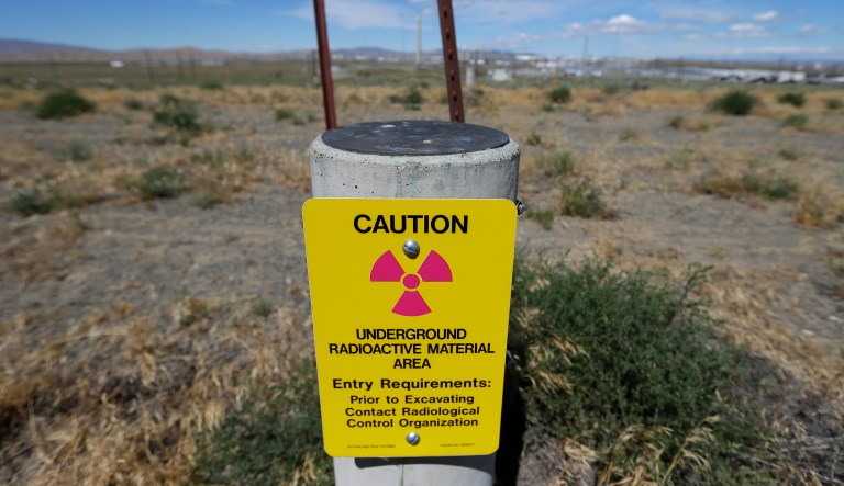 In this photo taken July 11, 2016, a sign warns of radioactive material stored underground on the Hanford Nuclear Reservation near Richland, Wash. The U.S. Energy Departmentâs top official at Washington stateâs severely contaminated  nuclear reservation says future accidental nuclear radiation releases are likely because of aging site infrastructure and inadequate cleanup funding.  Hundreds were evacuated May 9, 2017 when the roof of a 1950s rail tunnel storing a lethal mix of waste from plutonium production collapsed. Tests show no radiation was released.