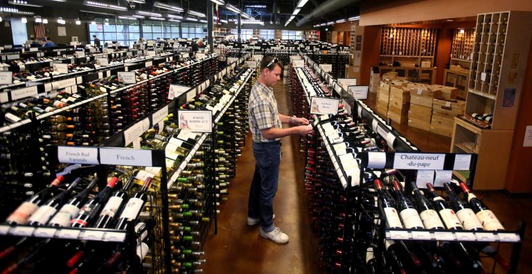 A worker at a state liquor store changes prices on wine, liquor, and higher-alcohol beer after closing to the public on June 30, 2017, near downtown Salt Lake City.