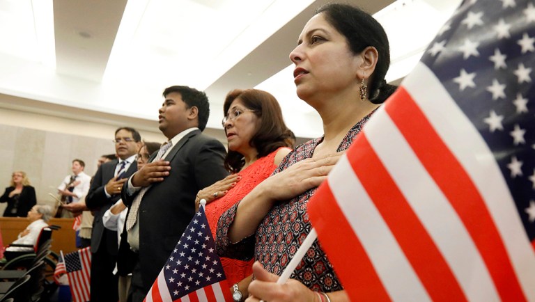 33 immigrants recite the Pledge of Allegiance during a naturalization ceremony.