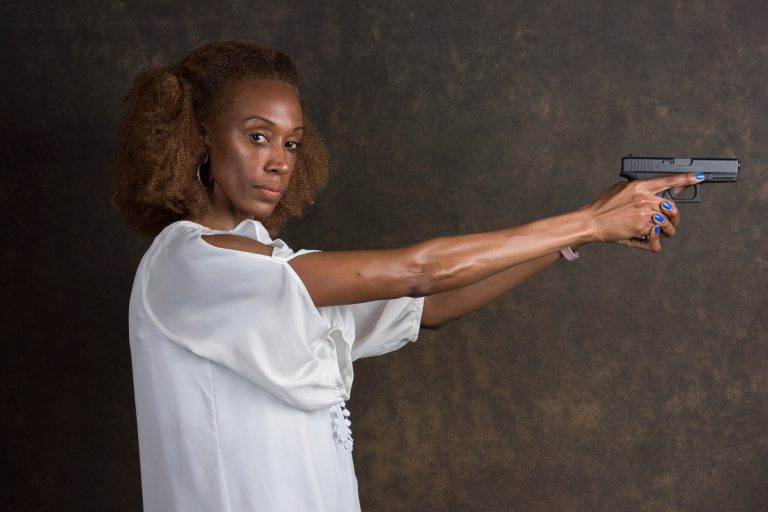 In this July 19, 2017, photo, Corelle Owens poses for a portrait in Decatur, Ga., while holding a Glock 40. Owens is a 45-year-old resident of Mableton, Ga., and flight attendant. She's among the ranks of the nation's black women who are learning how to use a firearm, deciding to go to the range and learn how to shoot after her car, phone, tablet and wallet were stolen.