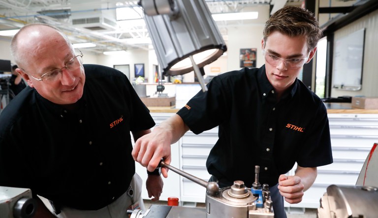 Apprentice Ryan Buzzy works with Skip Johnson, a trainer for the Stihl Inc. apprenticeship program, on a metalworking lathe in their training area at the Stihl manufacturing facility in Virginia Beach, Va., on May 25, 2017.