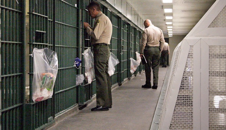 FILE - In this Oct. 3, 2012, file photo, Los Angeles County Sheriff's deputies inspect a cell block at the Men's Central Jail in downtown Los Angeles. The largest sheriff's department in the U.S. uses unsound methods to compile data about violence in Los Angeles County jails and provided inaccurate statistics about jailhouse assaults to news organizations and its oversight agency, according to a report released Wednesday Aug. 9, 2017.
