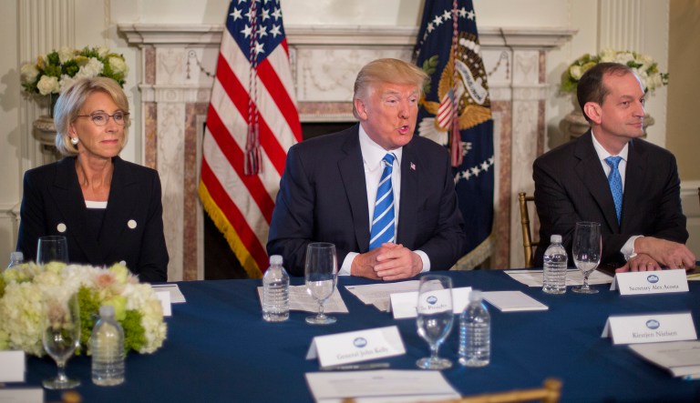 President Donald Trump, flanked by Education Secretary Betsy DeVos, left, and Labor Secretary Alexander Acosta, answers questions regarding the ongoing situation in North Korea, Friday, Aug. 11, 2017, at Trump National Golf Club in Bedminster, N.J.