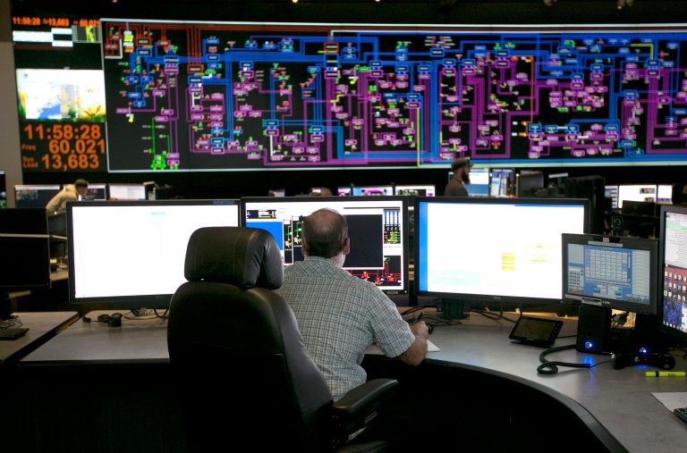 In this 2017 photo, electrical power flow and conditions are monitored at the Pacific Gas & Electric grid control center, in Vacaville, Calif.