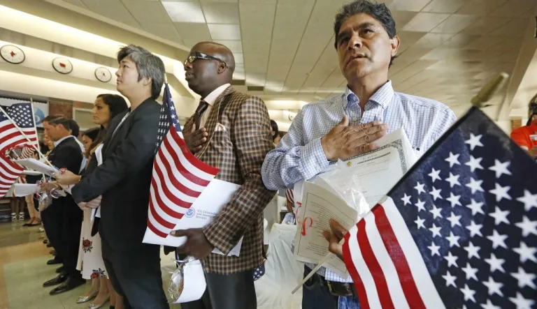 New citizens Eutropio Garcia Paz, of Mexico, right, Mamadou Sire Sall of Guinea, center, and Lucas Fei Lu of the People's Republic of China, were among 35 newly minted American citizens from 23 countries that sang the National Anthem at the conclusion of the naturalization ceremony at Northeast Jackson International Baccalaureate World Middle School in Jackson, Miss., Monday, Sept. 18, 2017.